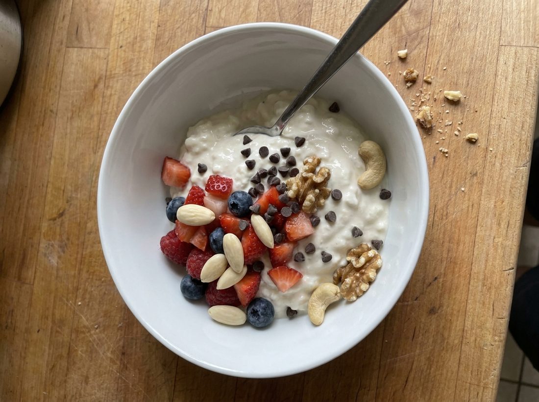 A yogurt bowl topped with berries, soaked nuts and chocolate chips